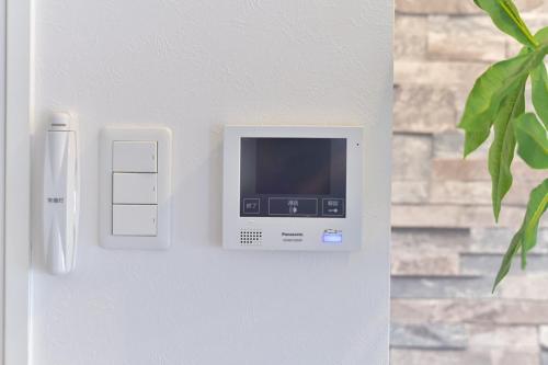 a computer on a wall next to a door at GLASS Yamahana EAST in Minami-jūichijō