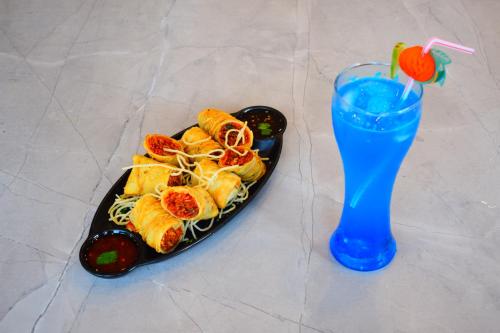 a plate of food and a drink next to a drink at Hotel 360 by D'Polo Dharamshala in Dharmsala
