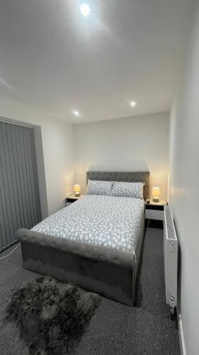 a bedroom with a bed and two tables and two lamps at 2 bed room luxury apartment in old Kent road London in London