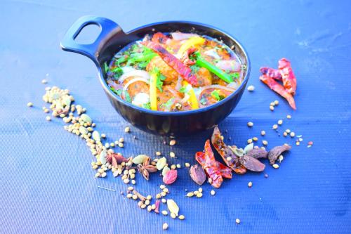 a pan of food on a blue table with seeds at Hotel 360 by D'Polo Dharamshala in Dharmsala