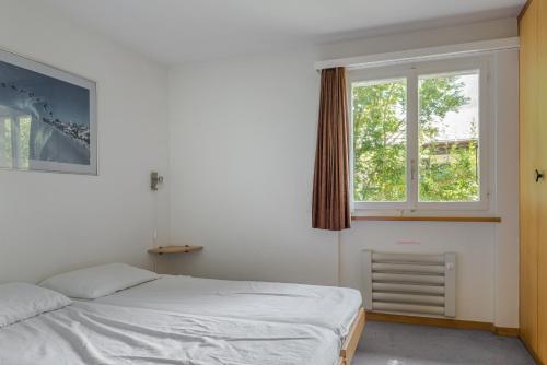 a bedroom with a bed and a window at Kirschstein OG in Fiesch