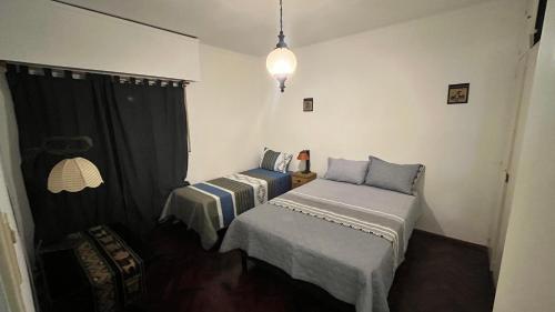 Habitación con 2 camas individuales y ventana. en Balcones De Capital en Vendimia en Mendoza