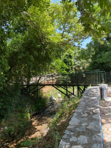 a wooden bridge over a path in a park at Costas Inn in Spílion