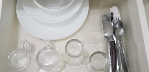 una mesa con utensilios de plata y un plato blanco en Innsite Room Rentals, en Manila