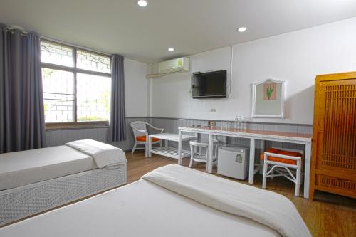 Cette chambre comprend deux lits et un bureau. dans l'établissement The Mercy Hotel, à Chumpon