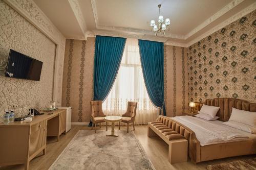 um quarto com uma cama, uma mesa e cadeiras em Comfort Hotel Samarkand em Samarkand