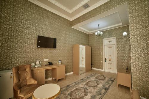 Cette chambre dispose d'un bureau et d'une télévision murale. dans l'établissement Comfort Hotel Samarkand, à Samarcande