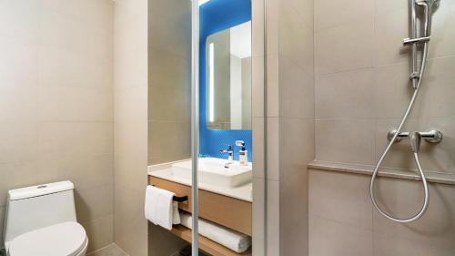a bathroom with a toilet and a sink at Holiday Inn Express Changsha Kaifu by IHG in Changsha