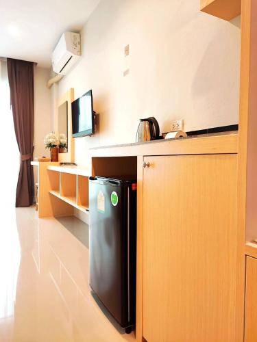 a kitchen with a black refrigerator next to a counter at The Beach at Klong Muang in Klong Muang Beach