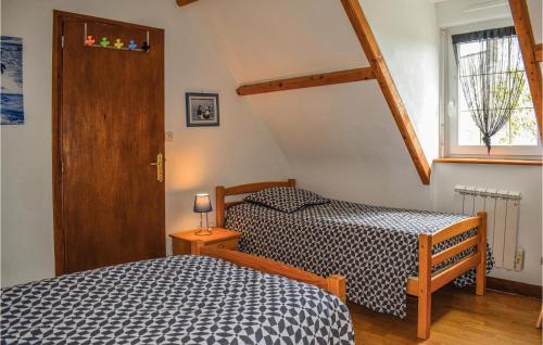 a bedroom with two beds and a window at Nice Home In Plouguiel With 2 Bedrooms in Plouguiel