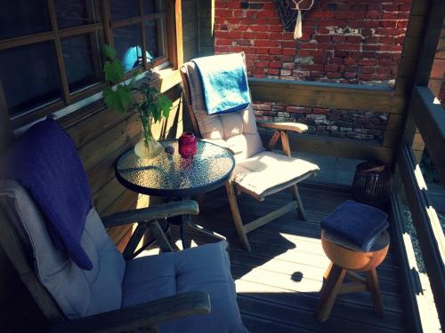 a patio with a table and chairs on a porch at Tiny House Bad Nieuweschans in Bad-Nieuweschans