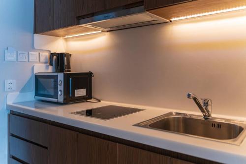 a kitchen counter with a microwave and a sink at SeaHaven Panorama Nha Trang Superview Apartments in Nha Trang