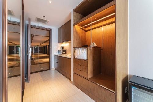 a kitchen with wooden cabinets and a walk in closet at MySea Panorama Nha Trang Superview Apartments in Nha Trang