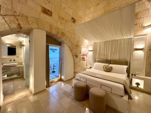 a bedroom with a large bed in a stone wall at Vittorio Emanuele Charming Suites in Monopoli