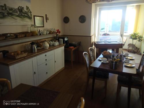 cocina con mesa, sillas y ventana en Gasthof Happe en Harth