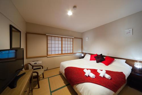a bedroom with a bed with two stuffed animals on it at Luna Lodge in Hakuba