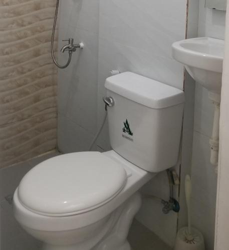 a bathroom with a white toilet and a sink at Innsite Room Rentals in Manila