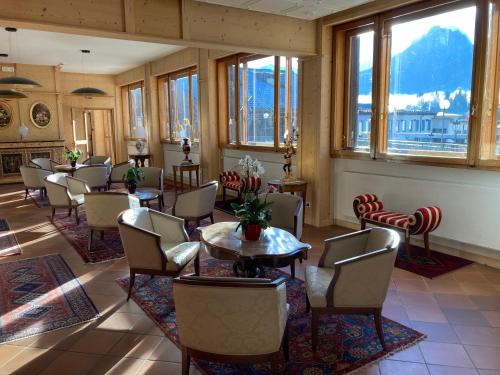 a dining room with tables and chairs and windows at Hotel Nevada in Tarvisio