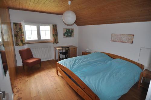 a bedroom with a bed and a chair and a table at Haus Noains in Rodels