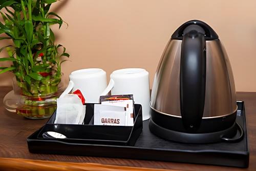 a coffee maker sitting on a table with cups at Stovehouse Inn in Ambāla