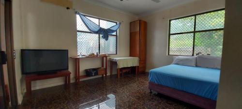a bedroom with a bed and a flat screen tv at Marine Apartments in Honiara
