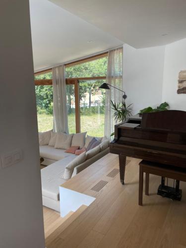 a living room with a piano and a couch at Zeehuis in Koksijde