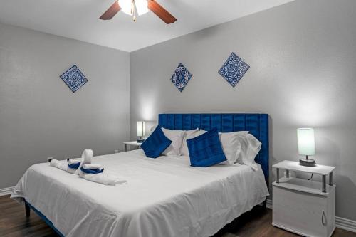 um quarto com uma cama azul e branca com almofadas azuis em Family Friendly 2bdrm-Walk To At&t/Cowboys Stadium em Arlington