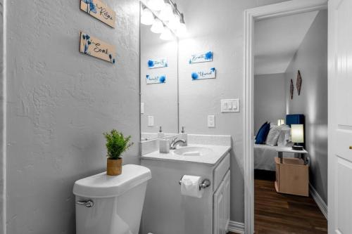 a bathroom with a toilet and a sink and a mirror at Family Friendly 2bdrm-Walk To At&t/Cowboys Stadium in Arlington