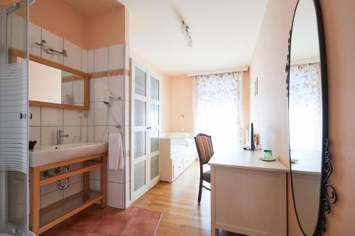 La salle de bains est pourvue d'un lavabo et d'un miroir. dans l'établissement Hotel San Marco, à Lannach