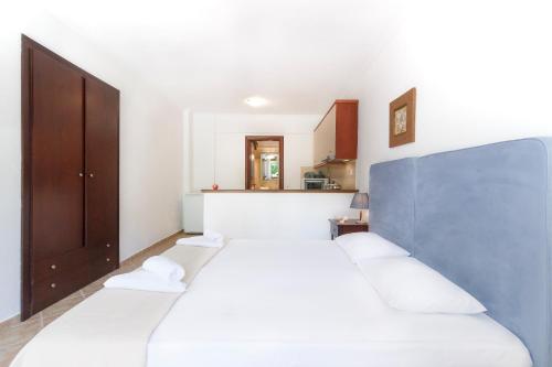 モラ・カリヴァにあるMaltinas Houseのベッドルーム1室(白いシーツが備わるベッド2台付)