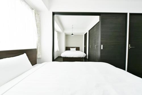 a bedroom with a large white bed and a window at Sun Court Hondori Garden Hills in Tsukisappu