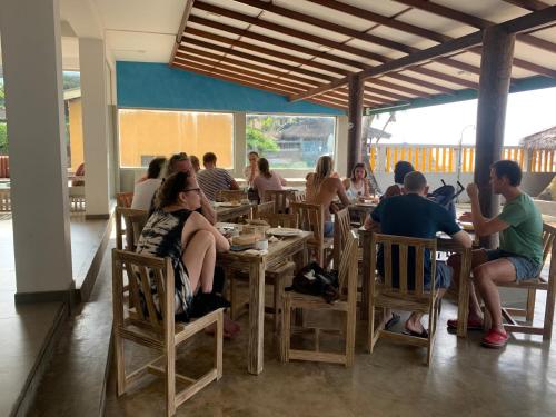 a group of people sitting at tables in a restaurant at Yula Beach in Hikkaduwa