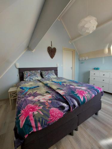 a bedroom with a bed with a colorful blanket at Siësta in Westkapelle