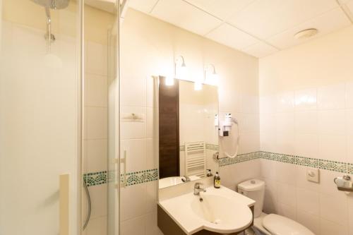 a bathroom with a sink and a toilet and a shower at Logis Hôtel Le Vert Galant in La Flèche