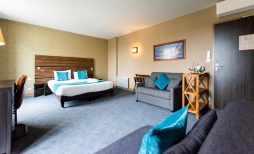 a hotel room with a bed and a couch at Logis Hôtel Le Vert Galant in La Flèche