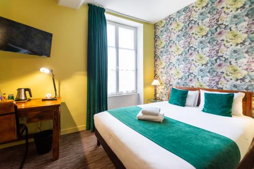 a bedroom with a bed and a desk and a window at Logis Hôtel Le Vert Galant in La Flèche