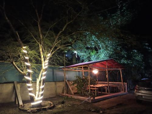 a gazebo with lights on it at night at Assam Villa - by Storyweavers Retreat in Jorhāt