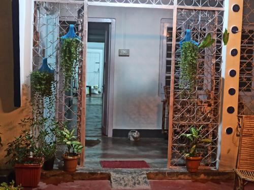 a hallway with a gate and potted plants at Assam Villa - by Storyweavers Retreat in Jorhāt