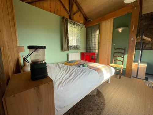 1 dormitorio con 1 cama con una batidora sobre una mesa en Jolie cabane avec jacuzzi pour les amoureux de la nature en Tullins