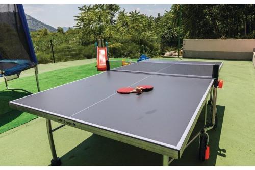 a ping pong table with a ping pong racket on it at Villa Heart of Stone in Ploče