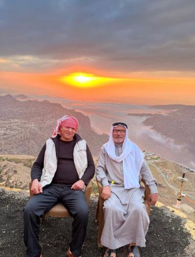 two people sitting on a chair on top of a mountain at Jabal Dana Hotel - the highest hotel in Jordan in Dana