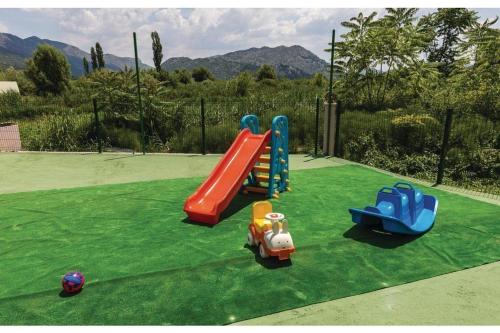 a playground with two play equipment on a green field at Villa Heart of Stone in Ploče