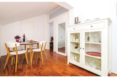 a dining room with a table and chairs and a white cabinet at Villa Heart of Stone in Ploče