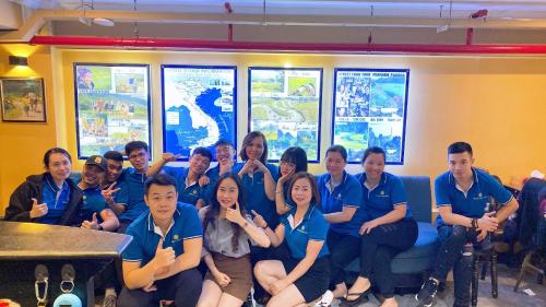 a group of people in blue shirts posing for a picture at Little Charm Hanoi Hostel in Hanoi