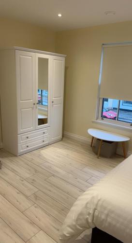 a bedroom with a bed and a table and a window at The Yellow Door in Castleisland