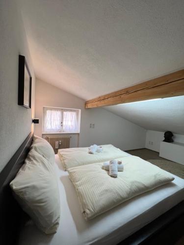 łóżko z 2 poduszkami i 2 ręcznikami w obiekcie Liboria: lovely,cosy apartment. 2 min skilift walk w mieście Campitello di Fassa