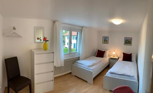 a bedroom with two beds and a window at Chalet zum See in Bregenz