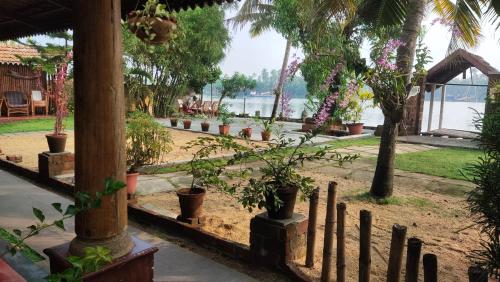 a garden with potted plants and a fence at Ambadi's villa -Lake view resort in Pallipuram