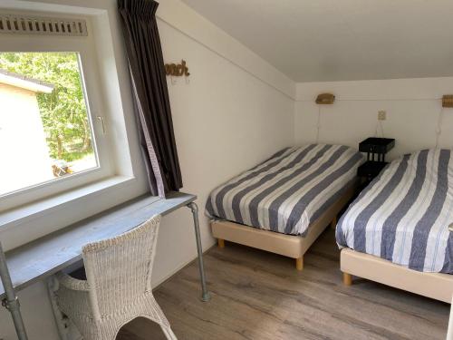 two beds in a room with a window at Haags Duinhuis - familyfriendly holidayhome in The Hague