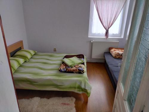 a small bedroom with a bed and a couch at CABANA ZIMBROAIA 8 camere -Muntii Bârgăului, Transilvania in Piatra Fantanele
